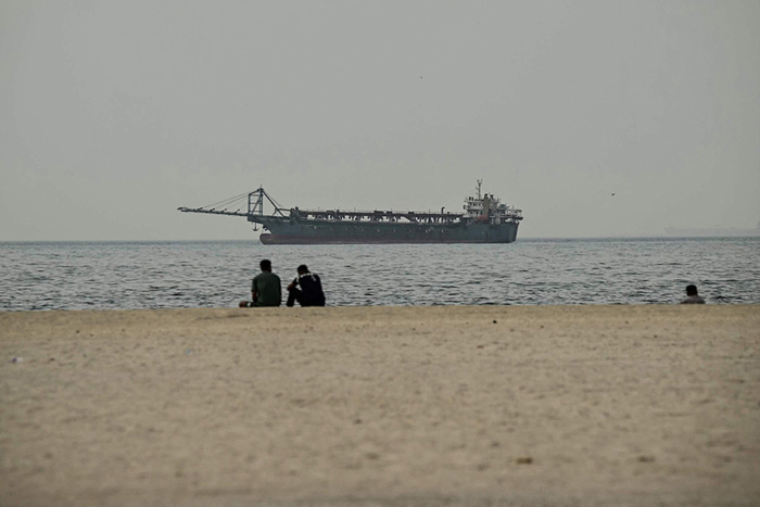 当地时间2026年3月2日，阿联酋迪拜，民众坐在阿吉曼海滩观看海上船只。&nbsp; 本文图均为 视觉中国 图