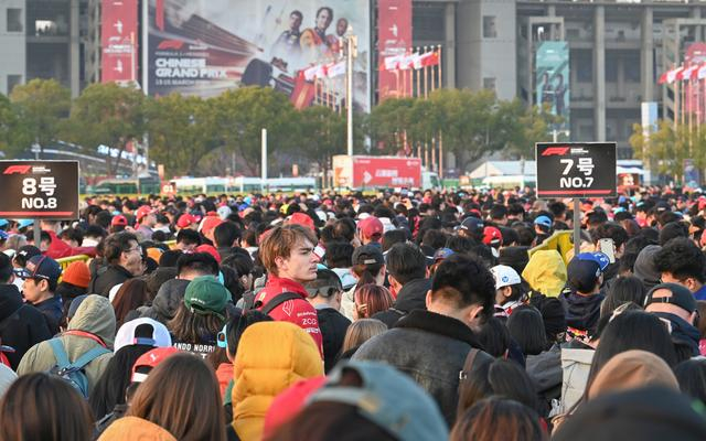 2026年3月13日，一位外国车迷看着比赛散场后涌向地铁站的人流陷入思考。澎湃新闻记者 吴栋 图
