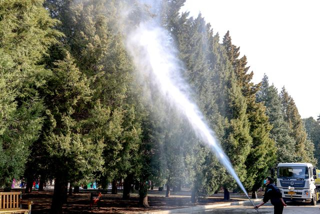 绿化工人正用高压水枪进行湿化作业。通讯员何建勇摄