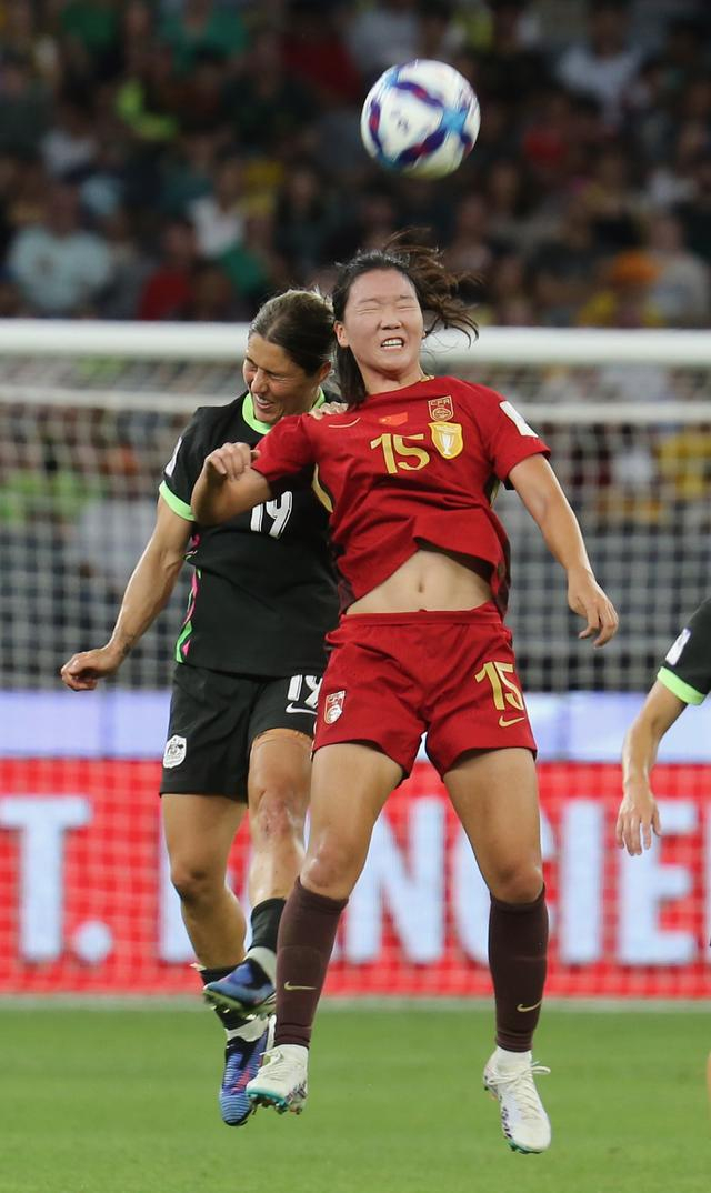 ↑ 中国队球员王爱芳（右）与澳大利亚队球员戈里在比赛中争顶。新华社发（周丹摄） 