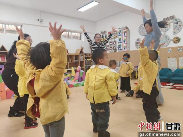 图为孩子们和老师跳舞互动。