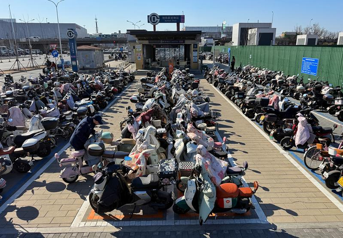 3月18日，地铁新发地站B口外，工作人员码放电动自行车。新京报记者 王贵彬 摄
