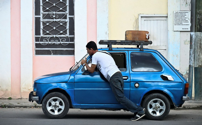 　2024年12月11日，古巴哈瓦那，一名男子在加油站附近推车。视觉中国 图