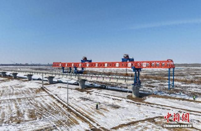 新建同江特大桥施工现场，架桥机将T型梁稳稳架设在墩柱间。 史轶夫 摄
