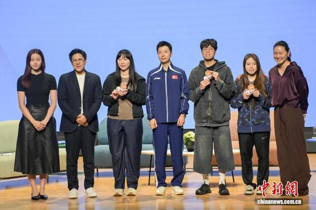 图为马龙（中）向提问的学生赠送纪念品并与学生们合影留念。中新网记者 陈永诺 摄 