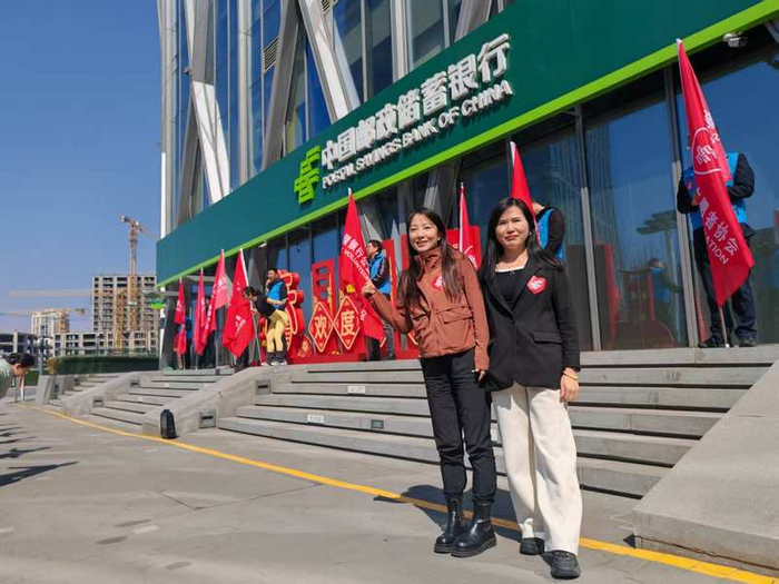 邮储银行北京通州区支行李冰（左）与邮储银行北京分行网络金融部肖利元（右）在“邮爱公益”活动现场。企业供图