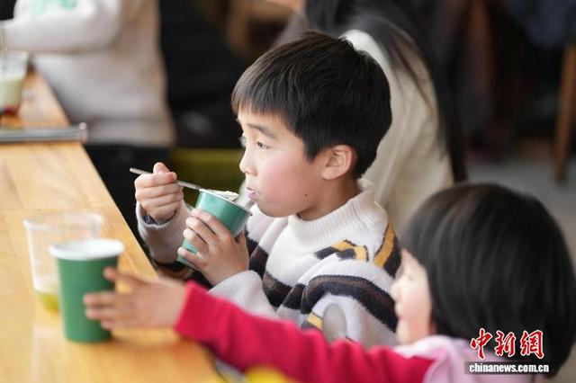 图为3月21日，小朋友在品尝“抹么茶”冰淇淋。刘鸿鹤 摄