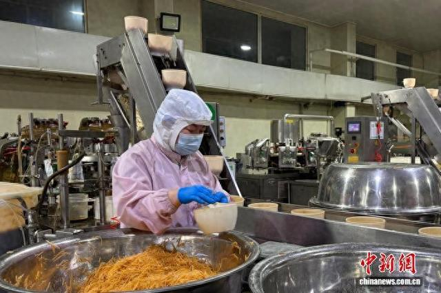 3月19日，内蒙古兴安盟，酱菜车间工人将腌制好的卜留克分装。 程凤娇 摄