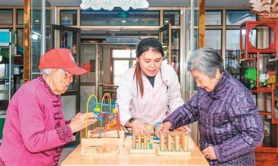 3月25日，在山东省胶州市一家养护院，护理人员在协助老人进行益智训练。王昭脉摄（新华社发）