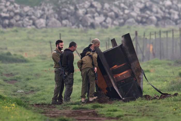 当地时间2026年3月19日，以色列戈兰高地，士兵在一处未公开地点检查一枚伊朗发射过来的导弹残骸。视觉中国 图