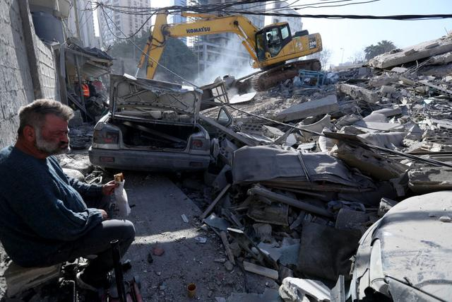 3月18日，在黎巴嫩贝鲁特，一名男子坐在被以色列空袭损毁的建筑前。新华社发（比拉尔·贾维希摄）