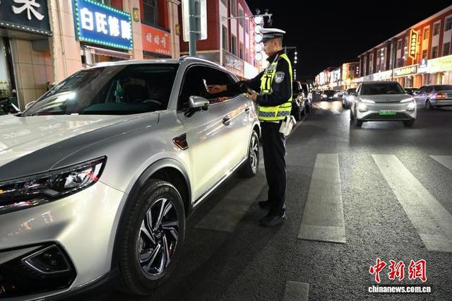 内蒙古呼和浩特，交警夜查违停车辆。 中新网记者 刘文华 摄