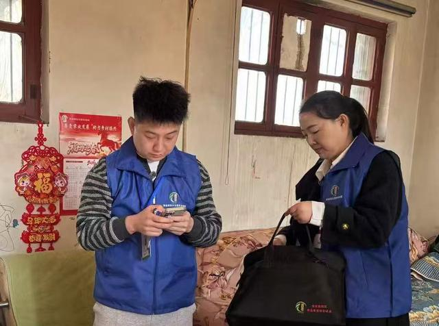 普查员周富强与普查指导员杨晓丽一起入户采集信息、填报数据。澎湃新闻记者 赵利新 摄