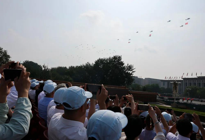 2025年9月3日，观礼嘉宾拍摄空中护旗梯队飞过天安门广场上空。