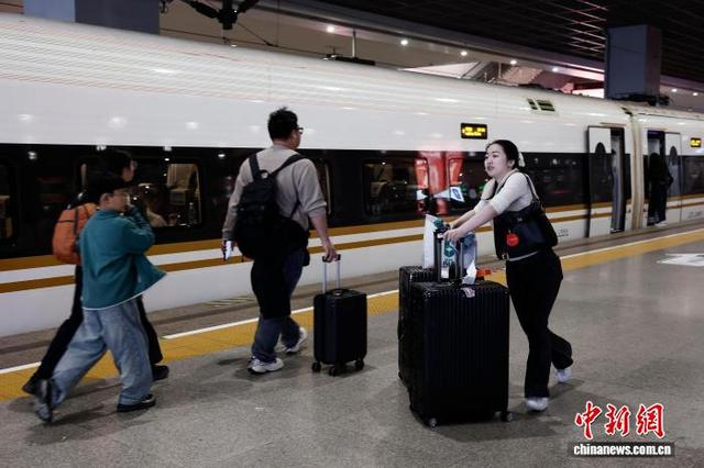 4月3日，旅客拖着行李在铁路上海虹桥站站台上行走。中新社记者 殷立勤 摄