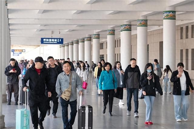 呼和浩特站迎来客流高峰。旅客们有序出站。杨颐 摄