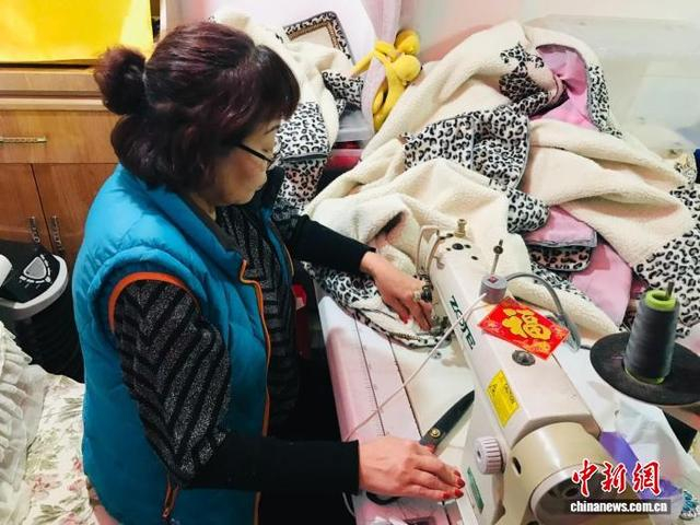 安宏此时正伏在缝纫机前赶制衣服。梅里斯达斡尔族区委宣传部 供图