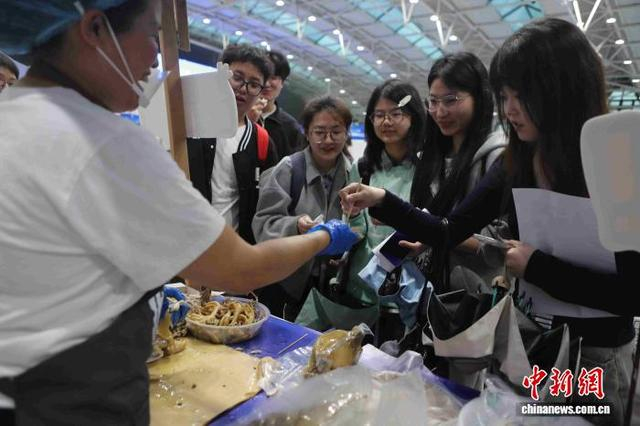 投递简历之余，同学们品尝起惠州特色美食盐焗鸡。惠州市供图