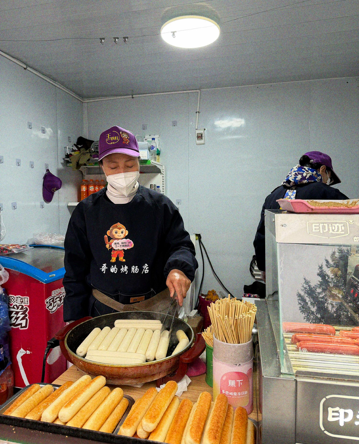 王铁柱的妈妈在烤肠店工作。 新京报记者 咸运祯 摄