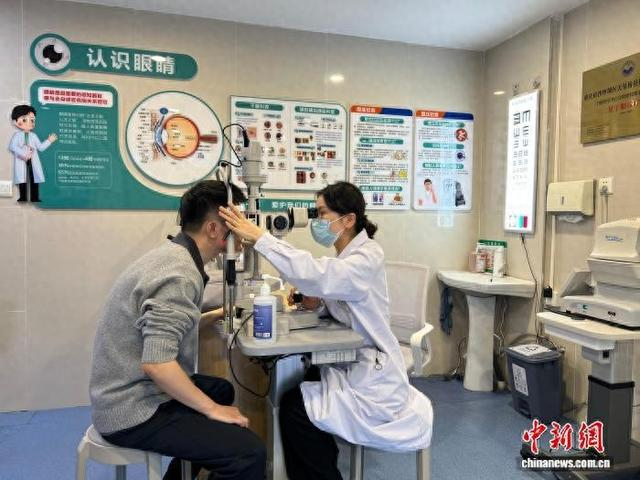 图为沙坪坝区天星桥社区卫生服务中心眼病诊疗中心内，医生张灵丽为居民进行眼部检查。中新网记者 钟旖 摄