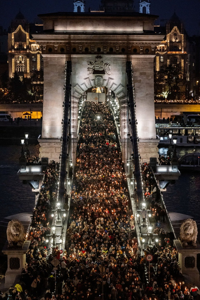 2025年12月13日，匈牙利布达佩斯，抗议者手持火把走过塞切尼链桥‌。视觉中国 图