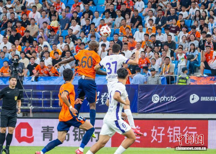 7月27日，坐镇主场的青岛海牛以2:0完胜天津津门虎。图为双方球员争顶皮球。冷金城 摄