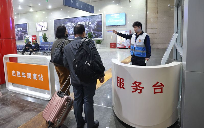 4月14日中午，北京南站南枢纽出租车调度站内，工作人员为旅客指引候车方向。新京报记者 王贵彬 摄