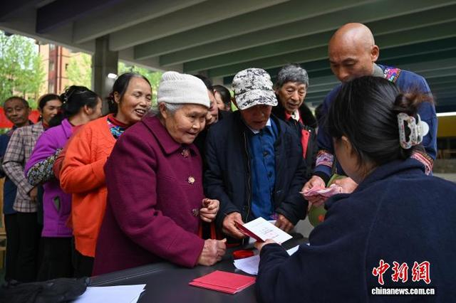 图为村民们排队领取现金分红。中新社记者 何蓬磊 摄
