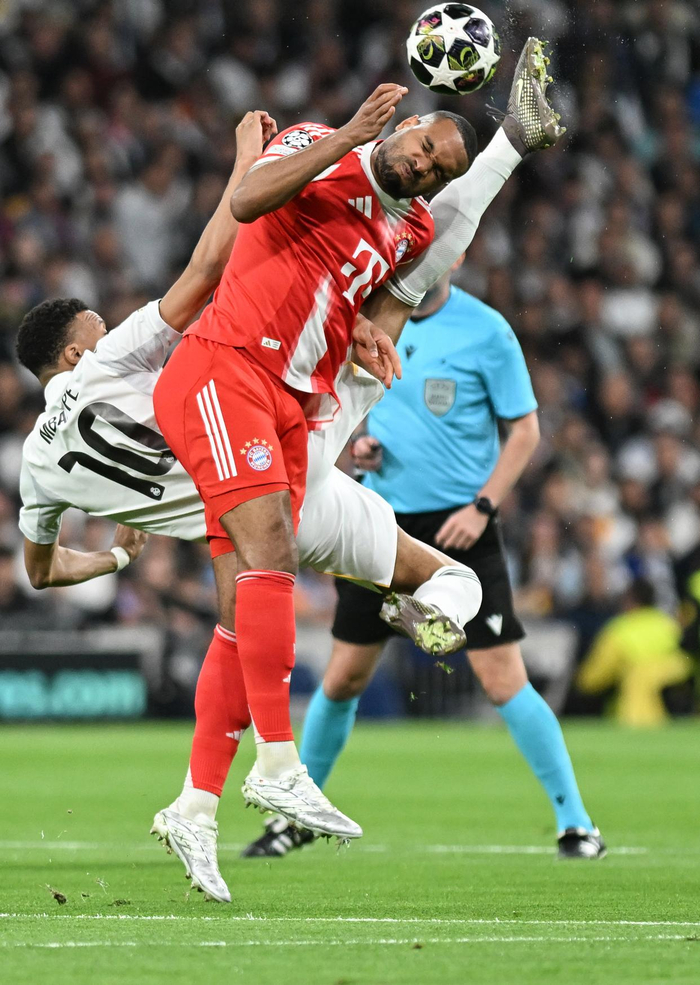 4月7日，皇家马德里队球员姆巴佩（左）与拜仁慕尼黑队球员约纳坦·塔在比赛中拼抢。新华社记者 程敏 摄