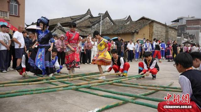图为民众在跳竹竿舞。何雯雯 摄