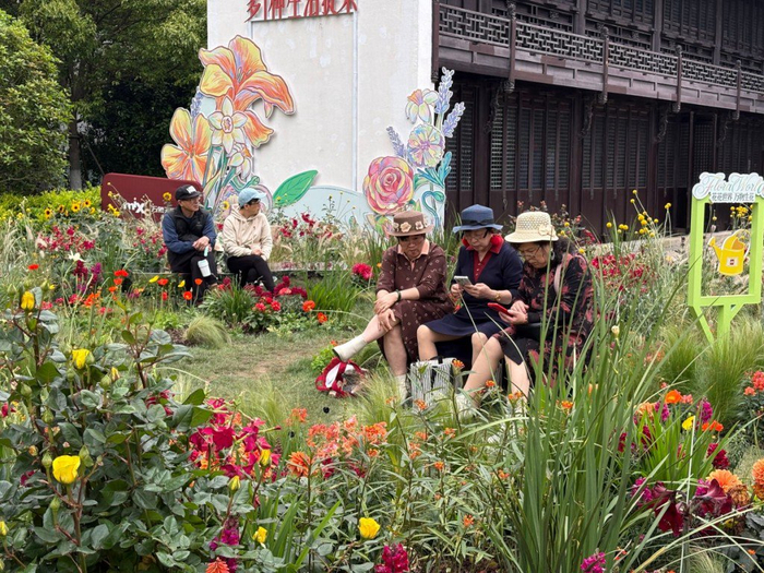 4月20日，游客在静安苏河湾的花丛间拍照休憩。澎湃新闻记者 陈悦 图