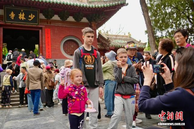 图为外籍游客在少林寺山门前合影留念。中新社记者 范晓恒 摄