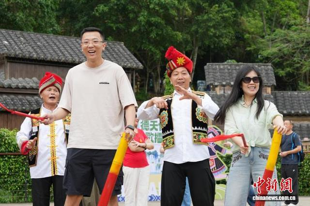 图为游客体验民俗表演。李源 摄