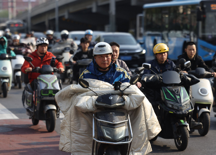 4月23日，东三环中路辅路双井桥下，六成左右的电动自行车骑行者戴上了头盔。新京报记者 王贵彬 摄