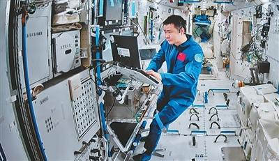 在北京航天飞行控制中心屏幕上拍摄的陈冬在空间站组合体舱内工作画面。 新华社记者 李明刚 摄