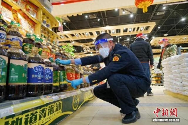 资料图为青海省西宁市，市场监管部门工作人员在超市内查看粮油价格。马铭言 摄