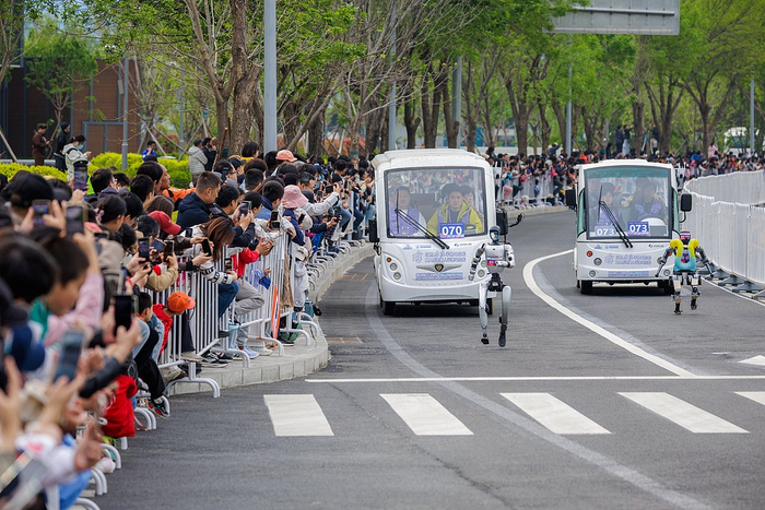 2026年4月19日，北京亦庄人形机器人半程马拉松赛场上，两台机器人“你追我赶”。视觉中国 图
