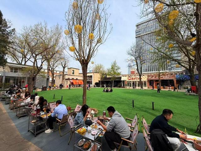 4月2日中午，食客在北京友谊商店室外草坪露天就餐。新华社记者 张骁 摄