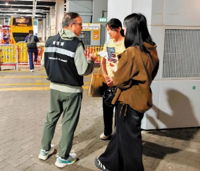 △香港特区政府卫生署控烟酒办人员在口岸向旅客讲解最新控烟政策