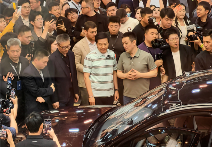 李斌与雷军交流；图源：虎嗅拍摄