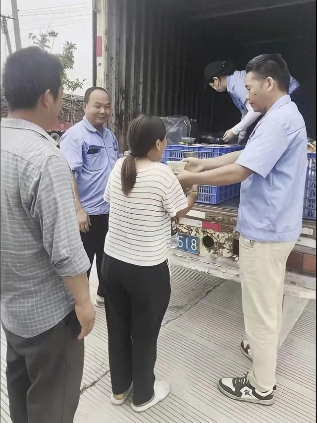 △工作人员在为司机们发放午餐。（图源羊城晚报）