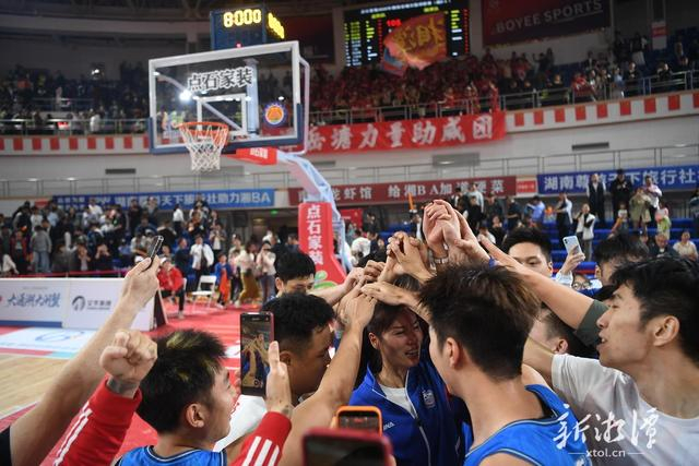 赛后大家相聚庆祝，教练喜极而泣。（全媒体记者 罗韬 摄）