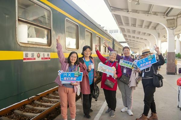 旅客在站台上与旅游专列合影。李超宇摄