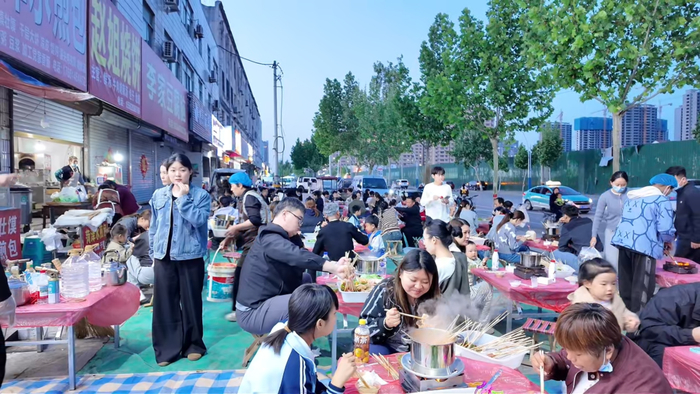 顾客在火锅店门口就餐的日常画面。新华社发