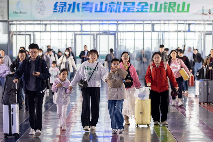 4月29日，在浙江省湖州站候车大厅，小旅客与家长检票进站。