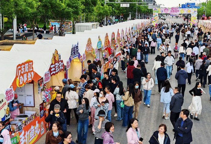 4月28日，北京国际花展期间，周边市集吸引附近写字楼的白领前来逛小吃街。