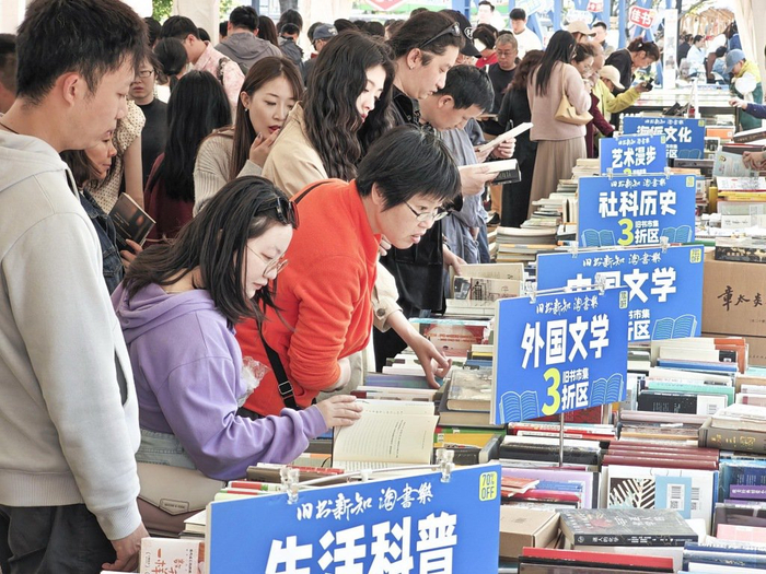 4月25日，上海，读者在樱花谷旧书市集淘书看书。