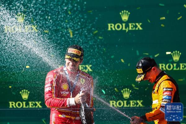 ↑塞恩斯（左）和诺里斯喷香槟庆祝。新华社发（钱俊摄）