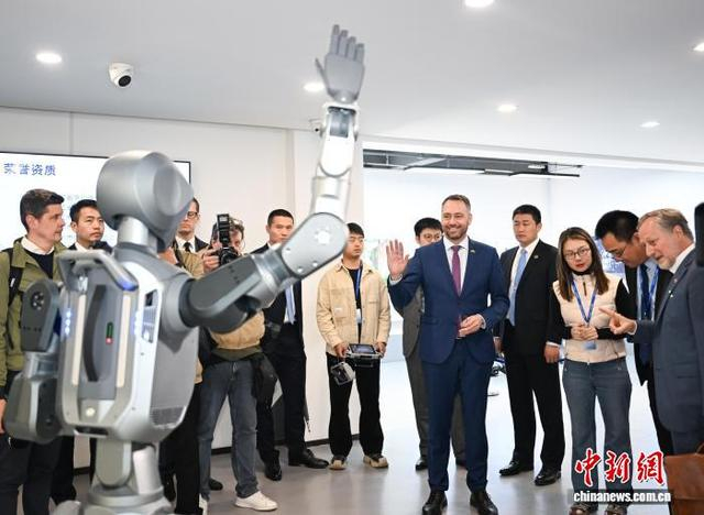 4月29日，普雷沃在杭州云深处科技股份有限公司和人形机器人招手致意。中新社记者 王刚 摄