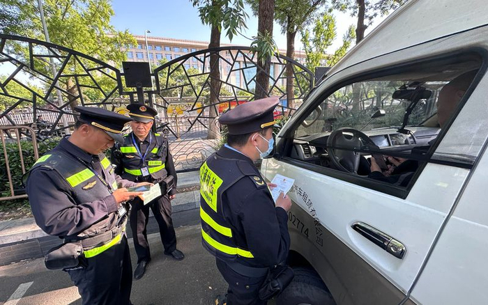 交通执法人员正在核查存在违规行为的旅游车辆信息。新京报记者 王贵彬 摄